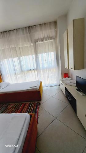 Großes Zimmer mit 2 Betten und einem Fenster in der Unterkunft Guesthouse Bela in Tirana