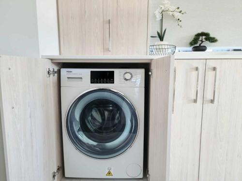 a washing machine in a cabinet in a room at Brand New Luxury 3BR Apartment in Christchurch CBD in Christchurch