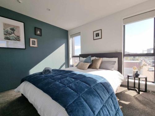 a bedroom with a large bed and a large window at CBD 3 Bedroom Apartment in Christchurch