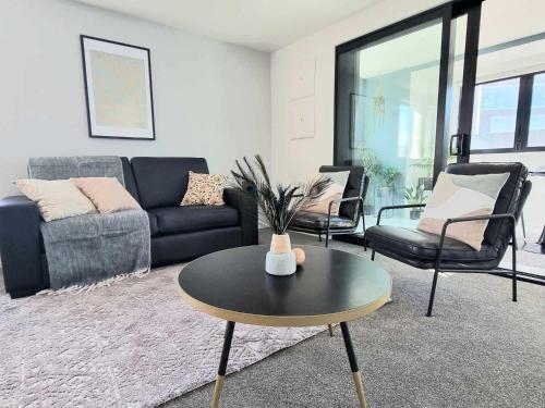 a living room with a couch and a table at Brand New Luxury 3BR Apartment in Christchurch CBD in Christchurch