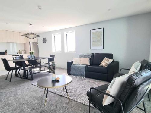 a living room with a couch and a table at Brand New Luxury 3BR Apartment in Christchurch CBD in Christchurch