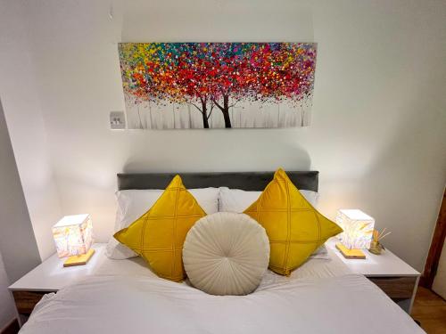 a bed with two yellow pillows and a painting on the wall at Seascape Bliss - Coastal Retreat in Youghal`s heart - Family Friendly - Long Term Price Cuts in Youghal