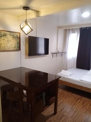 um quarto com uma secretária, uma cama e uma televisão em Z&J Transient Pad em Butuan