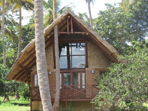 a small brick house with a large window at Simbamwenni Lodge and Camping in Morogoro
