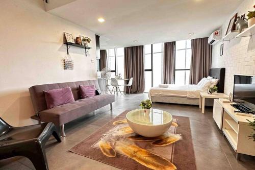 uma sala de estar com um sofá e uma mesa em Free Parking, 6pax Family Duplex Empire Damansara em Petaling Jaya