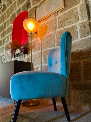 a blue chair sitting next to a brick wall at Libera Mente Civita in Bagnoregio