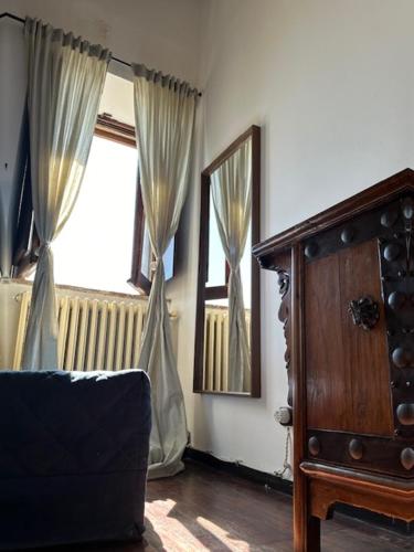 a living room with a chair and a mirror and a window at Libera Mente Civita in Bagnoregio