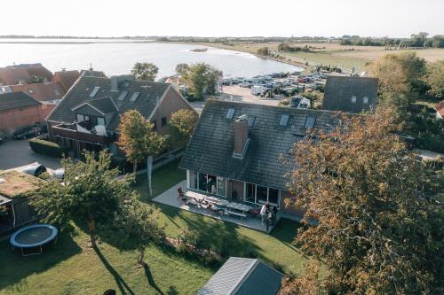 an aerial view of a house with a body of water at Primesurf House Fehmarn in Fehmarn
