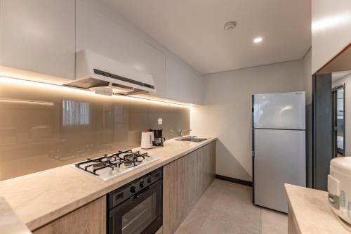 a kitchen with a stove and a refrigerator at Garden View Court Suites Ho Chi Minh City in Ho Chi Minh City