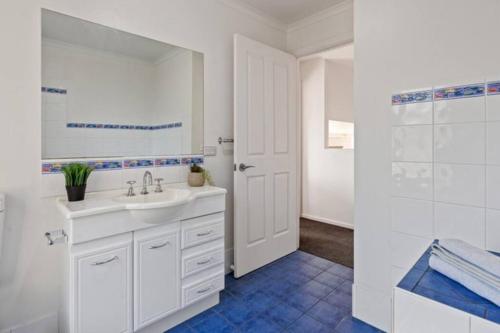 a white bathroom with a sink and a shower at Sapphire Sunrise in Merimbula