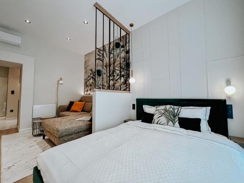 a bedroom with a large bed and a couch at Paulay 11 Center Designer Apartment in Budapest