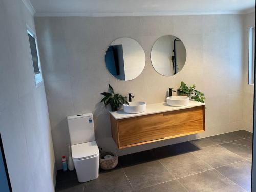 a bathroom with two sinks and two mirrors at Great Ocean Views Torquay in Torquay