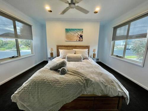a bedroom with a large bed with two windows at Great Ocean Views Torquay in Torquay