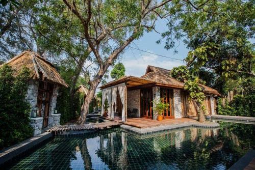 ein Haus mit einem Swimmingpool vor dem Haus in der Unterkunft The Journey Resort Pattaya in Na Jomtien