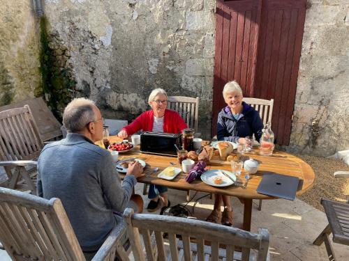un groupe de personnes assises autour d'une table en bois dans l'établissement Au Pied du Chateau, à Bourdeilles