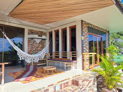 a porch with a hammock on a house at Sense Asia in Haad Tian