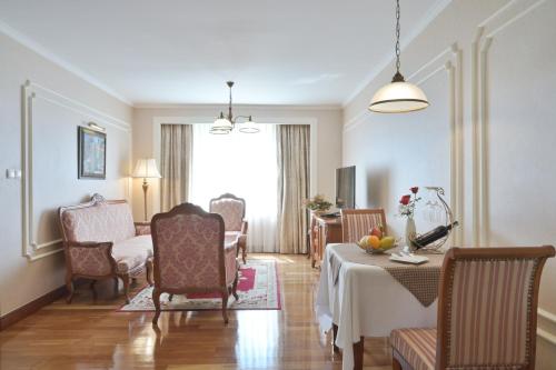 a living room with a table and chairs at Hotel Grand Saigon in Ho Chi Minh City
