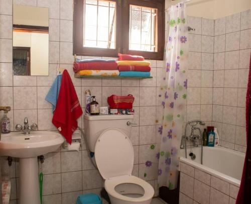 a bathroom with a toilet and a sink and a tub at Charming 2 bedroom house in Entebbe