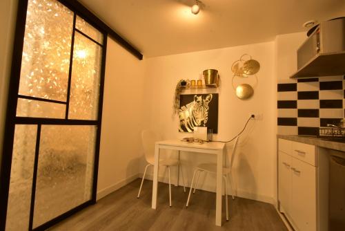 a small kitchen with a table and a window at Appartement jacuzzi Gold&Night in Verneuil d’Avre et d’Iton