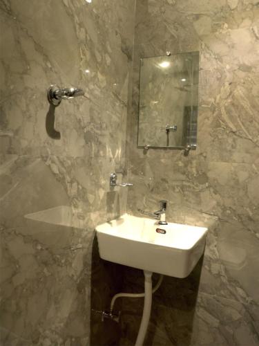 uma casa de banho com um lavatório e um espelho em Hotel Majestic em Ulhāsnagar