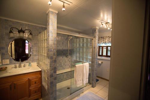 a bathroom with a shower and a sink and a mirror at Bees B & B in Mount Airy