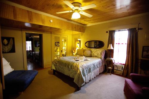 a bedroom with a bed and a ceiling fan at Bees B & B in Mount Airy