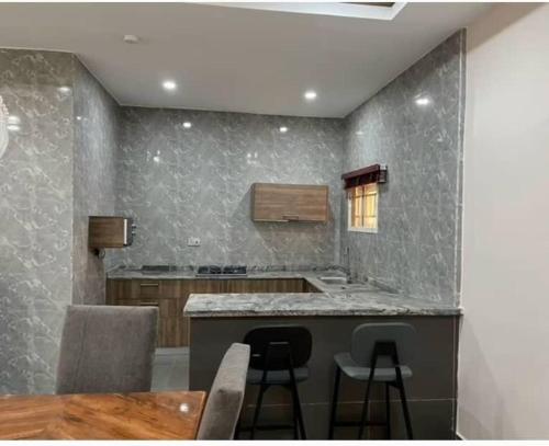 a kitchen with a counter and a table and chairs at Asher’s Villa in Garki