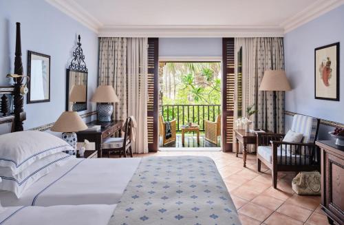 a hotel room with a bed and a desk and a balcony at Seaside Grand Hotel Residencia - Gran Lujo in Maspalomas