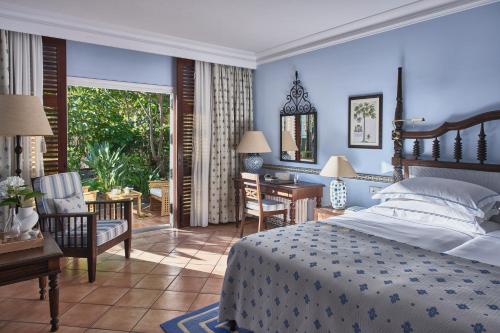 een slaapkamer met een bed, een bureau en een tafel bij Seaside Grand Hotel Residencia - Gran Lujo in Maspalomas