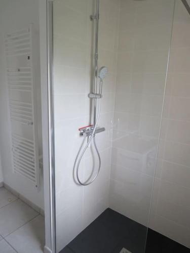 La salle de bains blanche est pourvue d'une douche avec un tuyau. dans l'établissement La Pellegrine, à Guiseniers