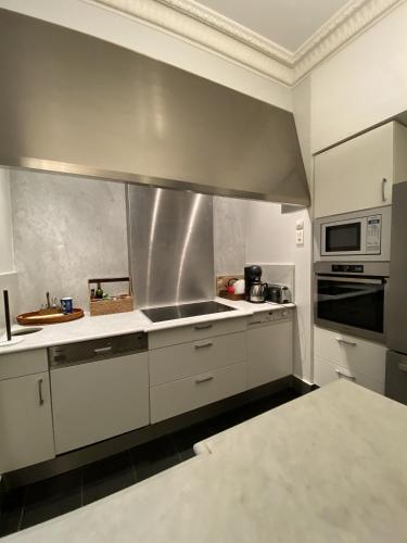 une cuisine avec des armoires blanches et un four à plaques de cuisson dans l'établissement ANNA CLAIRE festival plages GAZ5213, à Cannes