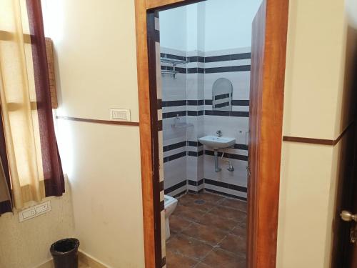 un piccolo bagno con servizi igienici e lavandino di Hotel High Society a Kota