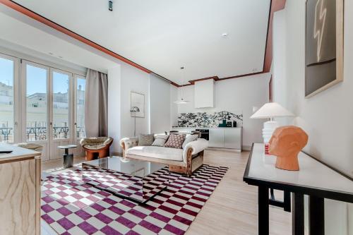 een woonkamer met een bank en een tafel bij Apartamentos Soho Boutique Hoy No Me Puedo Levantar in Madrid