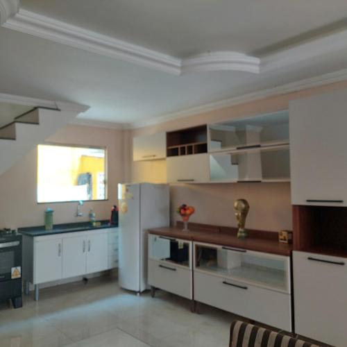 馬瑙斯的住宿－DUPLEX ALTO PADRÃO NO COND. OURO NEGRO - COROADO，厨房配有白色橱柜和白色冰箱。