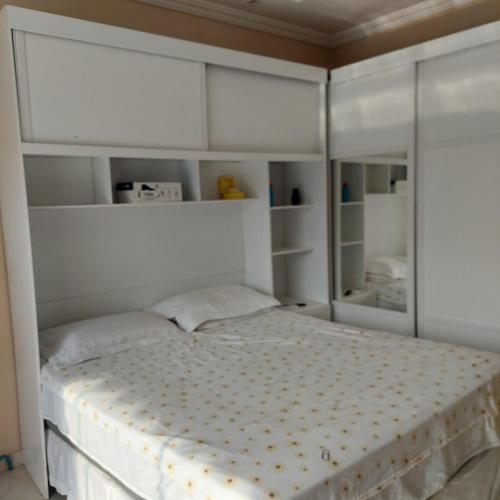 a bedroom with a large bed with white cabinets at DUPLEX ALTO PADRÃO NO COND. OURO NEGRO - COROADO in Manaus