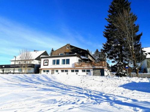 a house sitting on top of a snow covered yard at Gruppenhaus Haus BerchStein in Winterberg