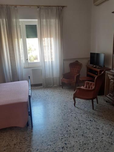 a bedroom with a bed and a tv and a chair at A casa di Adele in Caserta
