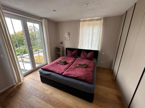 Un dormitorio con una cama con sábanas rojas y una ventana en Stadtvilla in Leipzig 7 Personen 3 Schlafzimmer 2 Bäder Garten und Terrasse zentral gelegen Messe Innenstadt Seen, en Leipzig