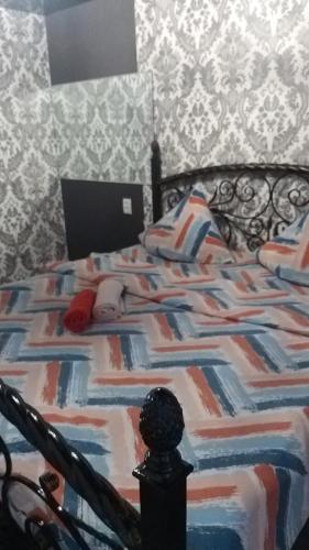 una camera da letto con un grande letto con un copriletto colorato di Квартира 3-х комнатная a Temirtaū