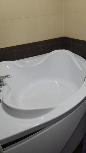 una vasca da bagno bianca seduta in bagno di Квартира 3-х комнатная a Temirtaū