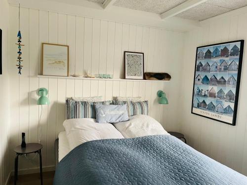 a bedroom with a bed with a blue blanket at Harbour Living in Hvide Sande