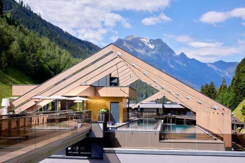 a building with a mountain in the background at ZillergrundRock Luxury Mountain Resort in Mayrhofen