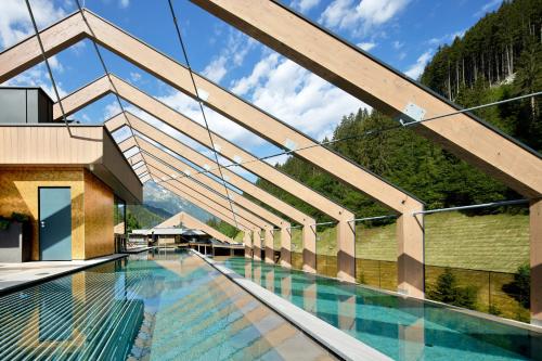 a swimming pool with a view of a mountain at ZillergrundRock Luxury Mountain Resort in Mayrhofen