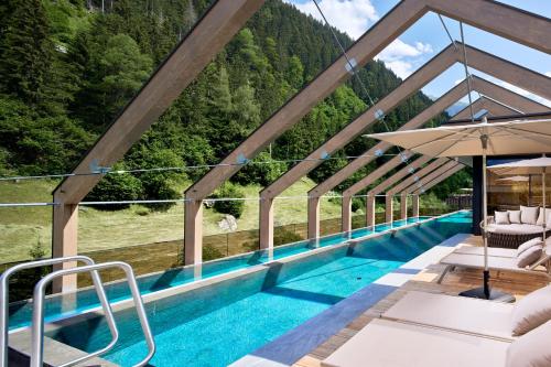 a swimming pool with a view of a mountain at ZillergrundRock Luxury Mountain Resort in Mayrhofen