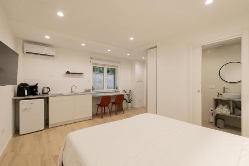 1 dormitorio blanco con 1 cama grande y cocina en Maison Nona, en Torre del Greco