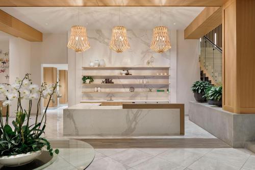 a lobby with potted plants and chandeliers at NOUN Hotel, Norman, a Tribute Portfolio Hotel in Norman