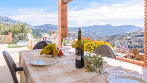 a table with a bottle of wine and a plate of fruit at Casa El Refugio de Árchez by Ruralidays in Árchez