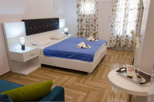 a small bedroom with a bed and a table at Polykratis Rooms in Skiathos Town