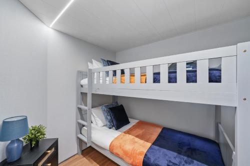 ロンドンにあるUnique Water Lodge in London - Sleeps 6の白い二段ベッドが備わる白い部屋のベッド1台分です。