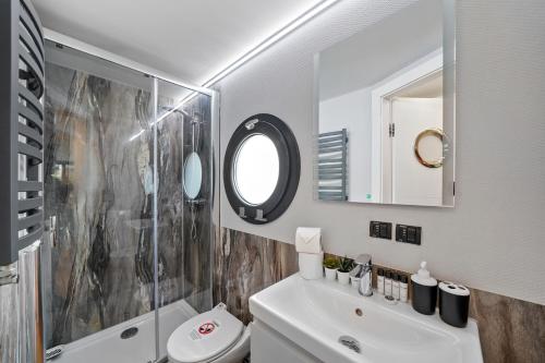 a bathroom with a sink and a shower and a toilet at Unique Water Lodge in London - Sleeps 6 in London